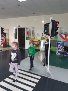 Zdjęcie wykonane na zajęciach w toruńskim WORDzie przedstawia dwójkę uczniów przechodzących po pasach na zielonym świetle.