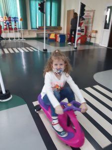 Zdjęcie wykonane na zajęciach w toruńskim WORDzie przedstawia uczennice przejeżdżającą na minirowerku po pasach.