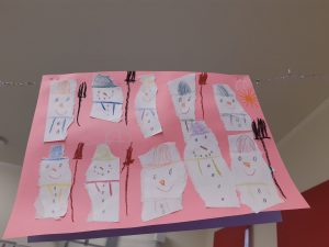 Na różowym tle umieszczono rysunki bałwanków.