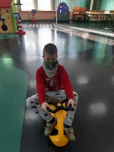 Zdjęcie wykonane na zajęciach w toruńskim WORDzie przedstawia ucznia siedzącego na mini rowerku.