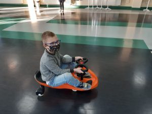 Zdjęcie wykonane na zajęciach w toruńskim WORDzie przedstawia ucznia siedzącego na mini rowerku.