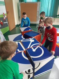 Zdjęcie wykonane na zajęciach w toruńskim WORDzie przedstawia uczniów składających znak drogowych z kolorowych sześcianów.