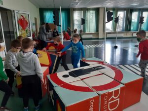 Zdjęcie wykonane na zajęciach w toruńskim WORDzie przedstawia uczniów układających znak drogowy z kolorowych kostek w kształcie sześcianów.