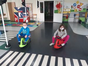 Zdjęcie wykonane na zajęciach w toruńskim WORDzie przedstawia dwoje uczniów jadących na mini rowerkach.