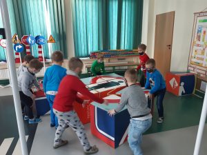 Zdjęcie wykonane na zajęciach w toruńskim WORDzie przedstawia uczniów układających znak drogowy z kolorowych sześciennych kostek.