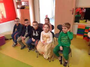 Szóstka uczniów siedzi na krzesełkach ustawionych jako widownia dla przedstawienia.