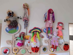 Zdjęcie wykonanych przez uczniów kukiełek symbolizujących marzanny, na tle białej ściany.