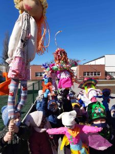 Zdjęcie uczniów wychodzących ze szkoły i niosących kukiełki które same wykonały.