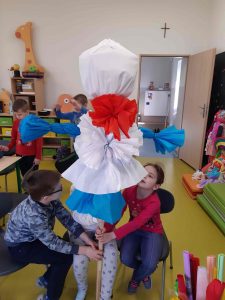 Zdjęcie dużej kukły trzymanej przez trójkę uczniów.