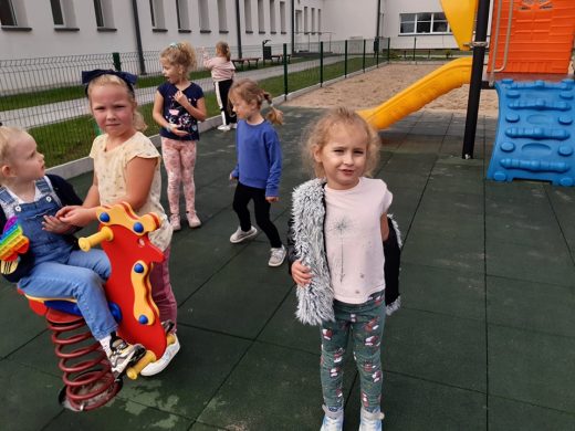 Uczniowie zerówki bawią się na placu zabaw.