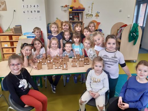 Uczniowie oddziału przedszkolnego zgromadzeni są w okół stołu na którym ustawiono modele misi.