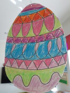 Zdjęcie wyciętej z papieru pisanki wykonanej przez ucznia.