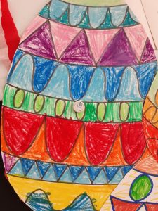 Zdjęcie wyciętej z papieru pisanki wykonanej przez ucznia.