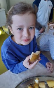 Uczennica je kawałek ugotowanego w skórce ziemniaka.