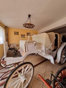 Zdjęcie eleganckiego białego powozu stojącego w garażu.