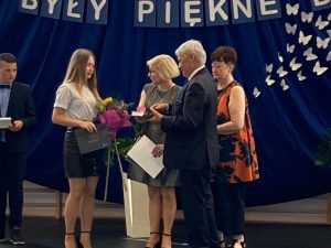 Wójt Gminy Łysomice, wraz z Panią Dyrektor i wychowawczynią klasy ósmej wręczają nagrodę dla najlepszej absolwent szkoły.