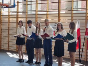 Przedstawiciele klasy ósmej - szóstka uczniów stoi w jednym rzędzie i odczytuje podziękowania dla nauczycieli.