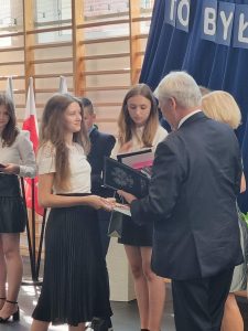 Wój Gminy Łysomice wręcza świadectwo z wyróżnieniem uczennicy klasy ósmej.