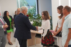 Uczennica Weronika Zielińska przyjmuje gratulacje z rąk wójta gminy Łysomice. Obok uczennicy stoją jej rodzice a za wójtem przedstawiciele gminy.