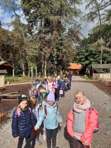 Uczniowie idą parami po ścierzce znajdującej się na terenie szkoly leśnej na Barbarce.