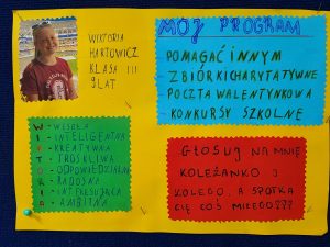 Zdjęcie plakatu kandydatki do małego Samorządu Uczniowskiego. W prawym górnymrogu zdjęcie uśmiechniętej kandydatki z podpisem '"WIKTORIA HARTOWICZ KLASA III 9 LAT". W okól na trzech kolorowych kartkach napisy. Na niebieskim tle: "MÓJ PROGRAM -POMAGAĆ INNYM, - ZBIÓRKI CHARYTATYWNE; - POCZTA WALENTYNKOWA; - KONKURSY SZKOLNE". Na czerwonym tle pod spodem :"GŁOSUJ NA MNIE KOLEŻANKO I KOLEGO A SPOTKA CIĘ COŚ MIŁEGO 111". Obok na zielonym tle w lewym dolnym rogu napis: "W - WESOŁA I - INTELIGENTA K-KREATYWNA T-TROSKLIWA O - ODPOWIEDZIALNA R - RADOSNA I - INTERESUJĄCA A- AMBITNA".