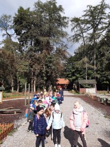 Uczniowie idą parami po ścierzce znajdującej się na terenie szkoly leśnej na Barbarce.