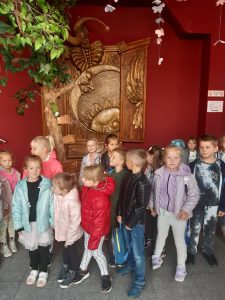 Uczniowie stoja obok siebie na tle czerwonej sciany w Baju pomorskim.