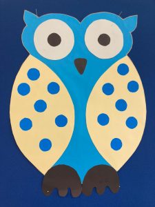 Zdjęcie wyciętej z papieru sowy ozdobionej niebieskimi kropkami.