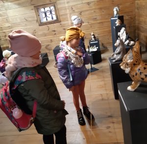 Uczniowie oddziału przedszkolnego podczas zwiedzania wystawy w Muzeum Etnograficznym. Dzieci przyglądają się eksponatom.