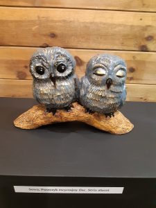 Zdjęcie eksponatów Muzeum Etnograficznego w Toruniu. Na wystawie dwie sówki siedzące na konarze.