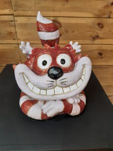 Zdjęcie eksponatu Muzeum Etnograficznego w Toruniu. Na wystawie figurka kota z Alicji w Krainie Czarów.