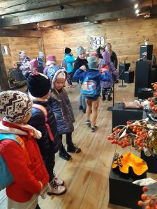 Uczniowie oddziału przedszkolnego podczas zwiedzania wystawy w Muzeum Etnograficznym. Dzieci przyglądają się eksponatom.