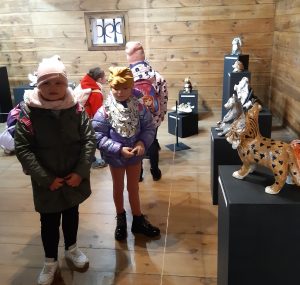 Uczniowie oddziału przedszkolnego podczas zwiedzania wystawy w Muzeum Etnograficznym. Dzieci przyglądają się eksponatom. Dwie dziewczynki stoją przodem do obiektywu.