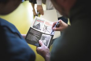 Zdjęcie trzymanej w dłoni gazety podczas składania na nim autografu przez Łukasza Kazka.