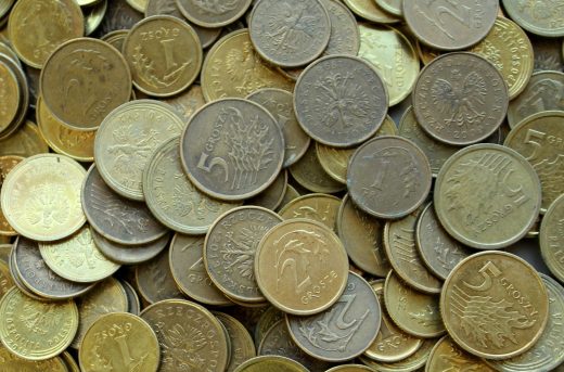 Zdjęcie monet polskich oułozonych przypadkowo na sobie o nominałach 1, 2 i 5 groszy.