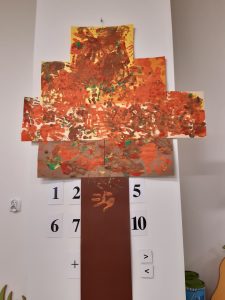 Zdjęcie wykonanej przez uczniów wspólnej jesiennej pracy. Nad długim brązowym prostokątem przyklejono kartki papieru z odciskami rączek dzieci w brązowej farbie.