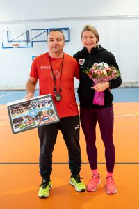Adrianna Sułek pozuje do zdjęcia z nauczycielem Kamilem Kontowiczem. Adrianna trzyma bukiet kwiatów a Pan Kamil ramkę ze zdjęciami.