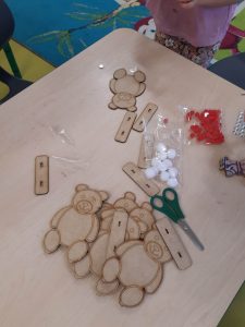 Na stoliku leżą elementy modeli misiów gotowe do złożenia przez dzieci.
