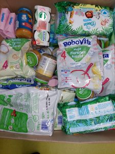 Zdjęcie wnętrza przygotowanego kartonu z darami zawierającego żywność i środki higieny dla małych dzieci.