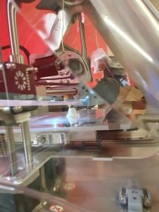 Zdjęcie drukarki 3D podczas drukowania pionka do gry.