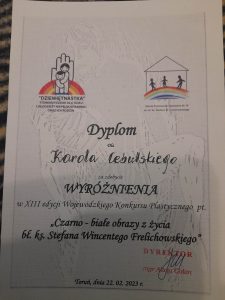 Zdjęcie dyplomu . Na jasnym tle z ryciną przedstawiająca postać trzymającą w dłoniach kobietę logo Stowarzyszenia dla dzieci i młodzieży niepełnosprawnej oraz ich rodzin oraz Szkoły podstawowej Selezjańskiej nr 19. Pod logami czarne napisy: "Dyplom Dla Karola Cebulskiego za zdobycie WYRÓŻNIENIA W XIII edycji Wojewódzkiego Konkursu Plastycznego pt. "Czarno-białe obrazy z życia bł. ks. Stefana Wincentego Frelichowskiego"". Poniżej pieczątka z podpisem dyrektora mgr Alicji Golon oraz napis "Toruń, dnia 22.02.2023 r.".