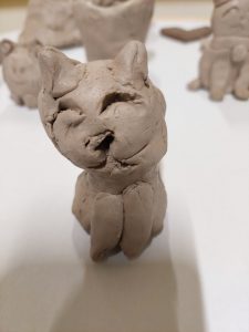 Zdjęcie figurki kotka wykonanej z gliny podczas warsztatów.