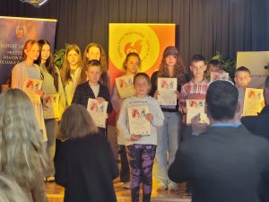 Nagrodzeni w konkursie uczniowie pozują do wspólnego zdjęcia z otrzymanymi dyplomami.