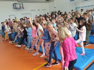 Uczniowie szkoły podczas audycji muzycznej. Dzieci tańczą.