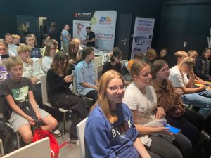 Uczniowie klasy ósmej siedzą na krzesełkach podczas spotkania motywacyjnego matma^2