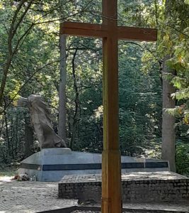 Zdjęcie krzyża a za nim pomnika ustawionych w miejscu pamięci na Barbarce.