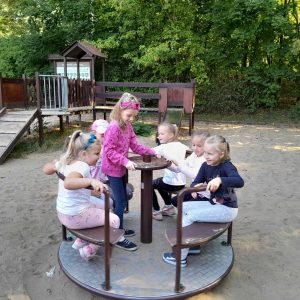 Uczniowie oddziału przedszkolnego kręcą się na karuzeli.