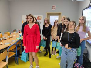 Uczennice klasy siódmej stoją w grupie. Dziewczynki trzymają w dłoni torebki z prezentami.