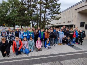 Uczniowie pozują do wspólnego zdjęcia przed budynkiem muzeum powstania państwa polskiego.