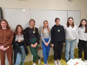 Uczniowie klasy siódmej pozują do wspólnego zdjęcia mając naklejone na ubraniu odznaki "Mistrza Tabliczki Mnożenia".